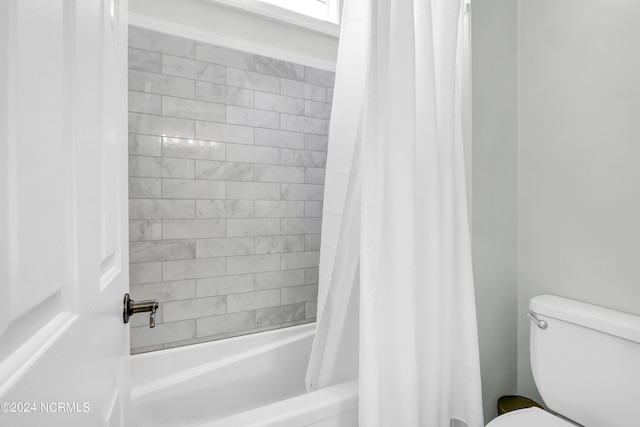 full bathroom with shower / bath combo with shower curtain and toilet