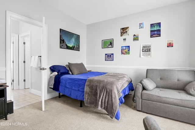 bedroom with baseboards, light carpet, and light tile patterned flooring