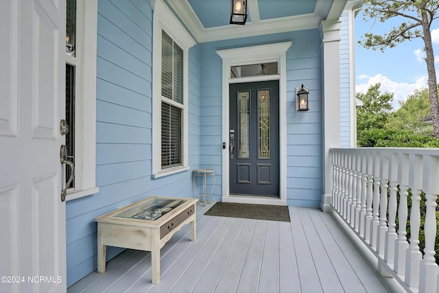 view of exterior entry featuring covered porch