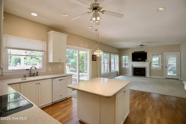21 Birdie Dr, Whispering Pines, NC 28327 - kitchen featuring white dishwasher, a sink, a fireplace, a textured ceiling, and a ceiling fan