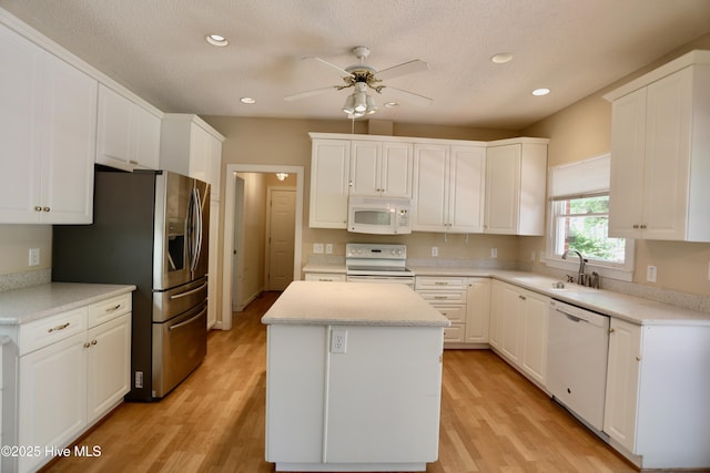 21 Birdie Dr, Whispering Pines, NC 28327 - kitchen with a sink, white appliances, light wood-style flooring, a ceiling fan, and a kitchen island