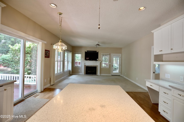 21 Birdie Dr, Whispering Pines, NC 28327 - unfurnished living room with a fireplace, a textured ceiling, ceiling fan with notable chandelier, recessed lighting, and visible vents