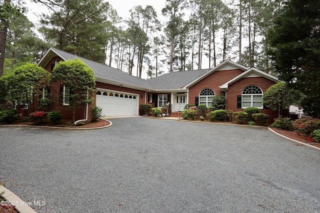21 Birdie Dr, Whispering Pines, NC 28327 - ranch-style house with an attached garage, driveway, and brick siding