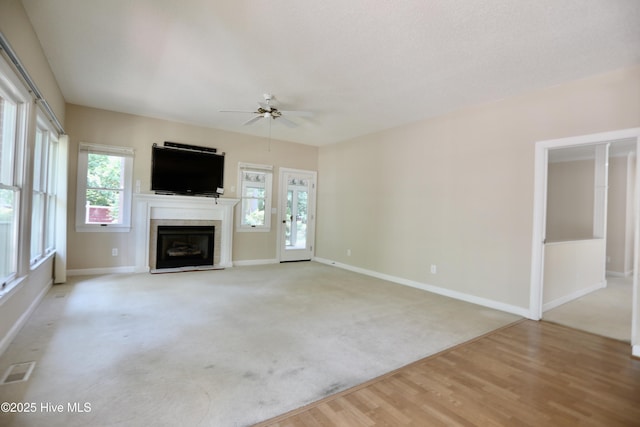 21 Birdie Dr, Whispering Pines, NC 28327 - unfurnished living room featuring baseboards, ceiling fan, a healthy amount of sunlight, and a tile fireplace