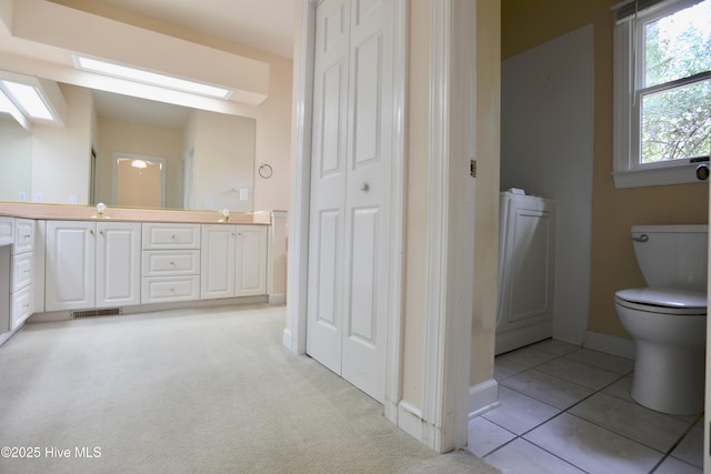 21 Birdie Dr, Whispering Pines, NC 28327 - full bath featuring double vanity, tile patterned flooring, baseboards, toilet, and carpet