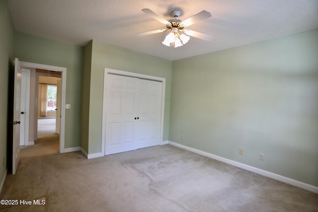 21 Birdie Dr, Whispering Pines, NC 28327 - unfurnished bedroom with a closet, light carpet, baseboards, a textured ceiling, and a ceiling fan