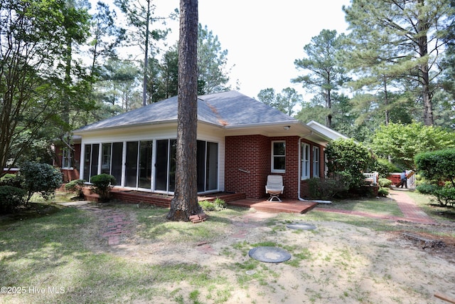 21 Birdie Dr, Whispering Pines, NC 28327 - rear view of property featuring brick siding, a wooden deck, and a sunroom