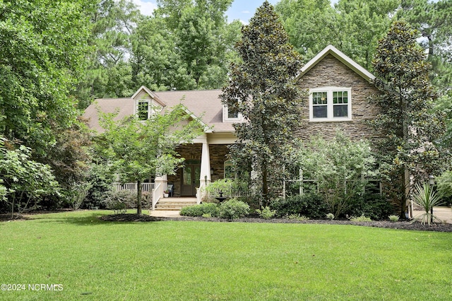 view of front facade with covered porch, stone siding, and a front lawn