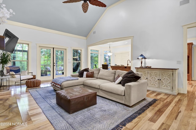 living room featuring visible vents, light wood-style flooring, a ceiling fan, and high vaulted ceiling