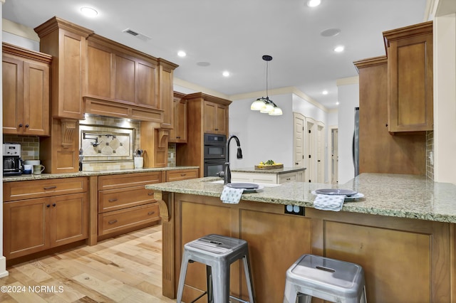 kitchen with a peninsula, decorative backsplash, visible vents, and brown cabinets