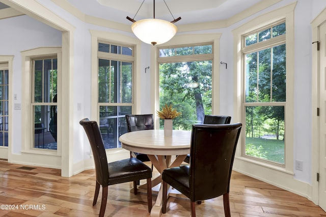 dining area with baseboards, light wood-style flooring, and visible vents