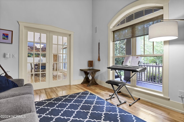 living area with baseboards, french doors, visible vents, and wood finished floors