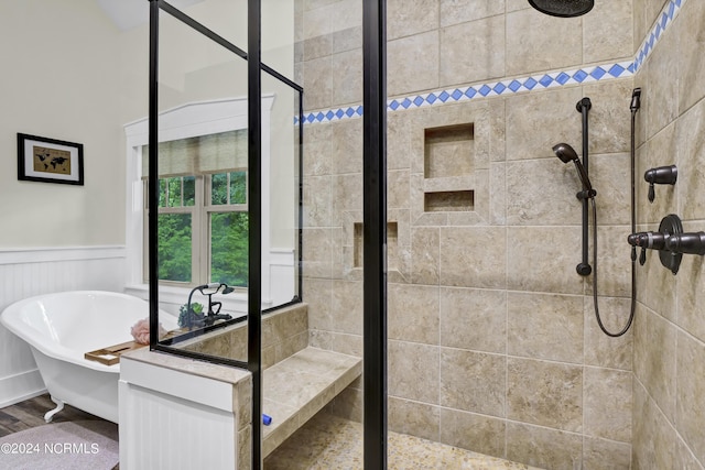 full bathroom featuring a stall shower, wainscoting, and a freestanding bath