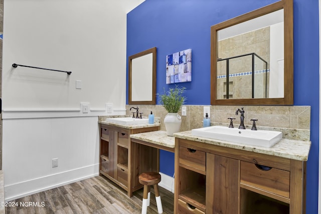 bathroom featuring a sink, wainscoting, a shower stall, and wood finished floors