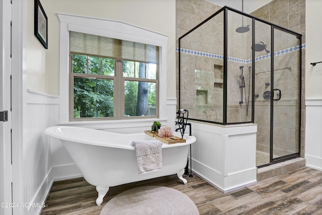 full bath with a shower stall, a soaking tub, and wood finished floors
