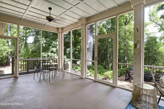 unfurnished sunroom featuring ceiling fan