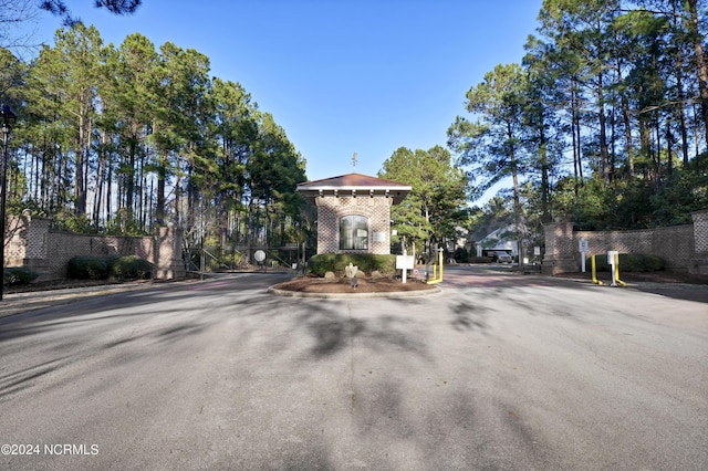 view of road featuring a gated entry and curbs