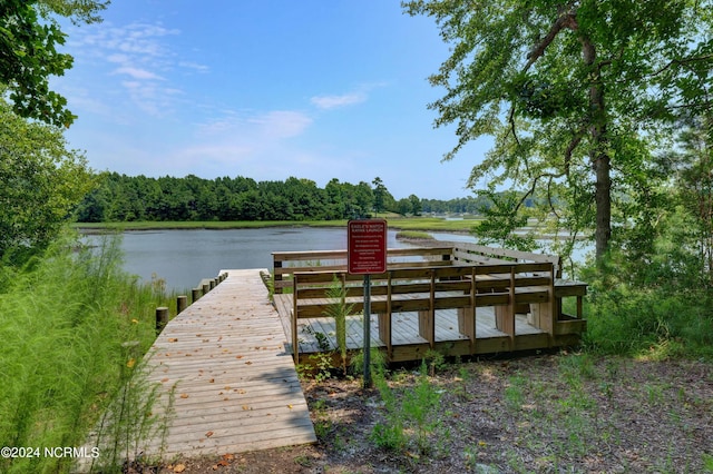 dock area with a water view and a wooded view