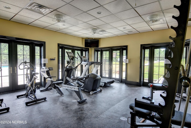 workout area with a drop ceiling, visible vents, french doors, and baseboards