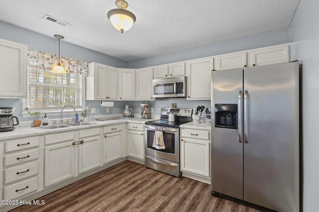kitchen with visible vents, a sink, a textured ceiling, and appliances with stainless steel finishes