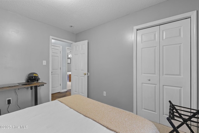 bedroom with a textured ceiling and a closet