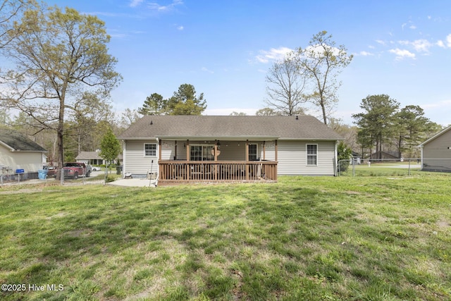 rear view of property with a yard, roof with shingles, and a fenced backyard