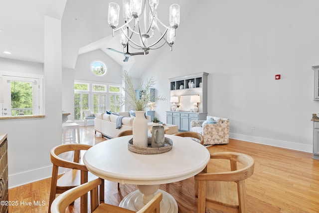 2537 St James Dr SE Apt 1011, Southport, NC 28461 - dining area featuring a notable chandelier, high vaulted ceiling, light wood-style flooring, and baseboards