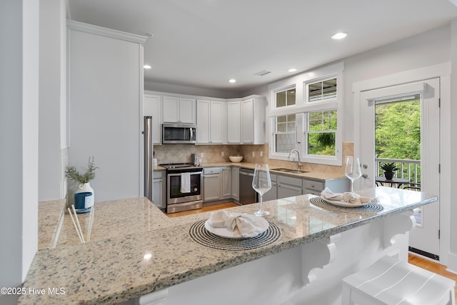 2537 St James Dr SE Apt 1011, Southport, NC 28461 - kitchen featuring tasteful backsplash, stainless steel appliances, light stone counters, and a sink