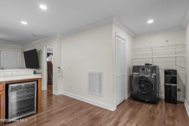 laundry area with beverage cooler, laundry area, visible vents, crown molding, and washer / clothes dryer