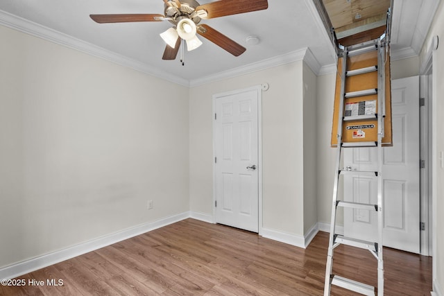 interior space with ceiling fan, baseboards, crown molding, and wood finished floors