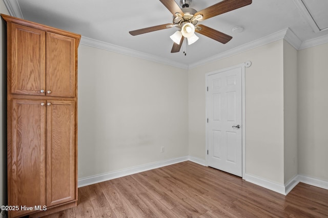 unfurnished bedroom with wood finished floors, a ceiling fan, baseboards, and ornamental molding