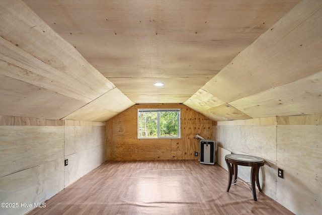 bonus room with light wood-type flooring and lofted ceiling
