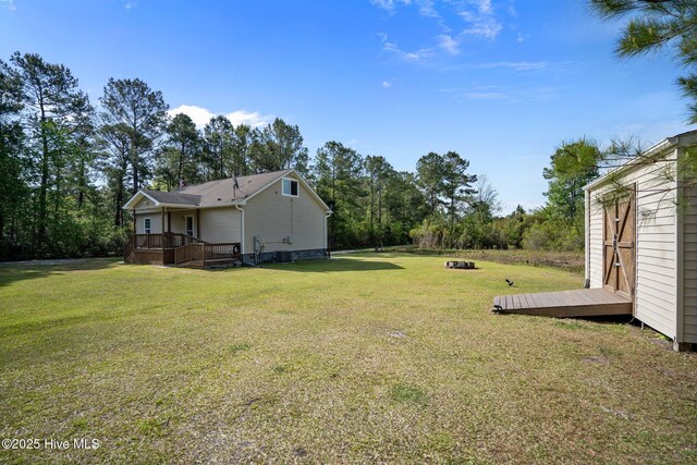 view of yard featuring an outdoor structure and a wooden deck