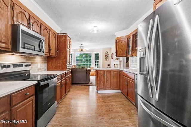 105 Harbor Dr, Washington, NC 27889 - kitchen featuring light countertops, appliances with stainless steel finishes, brown cabinetry, and light wood-type flooring