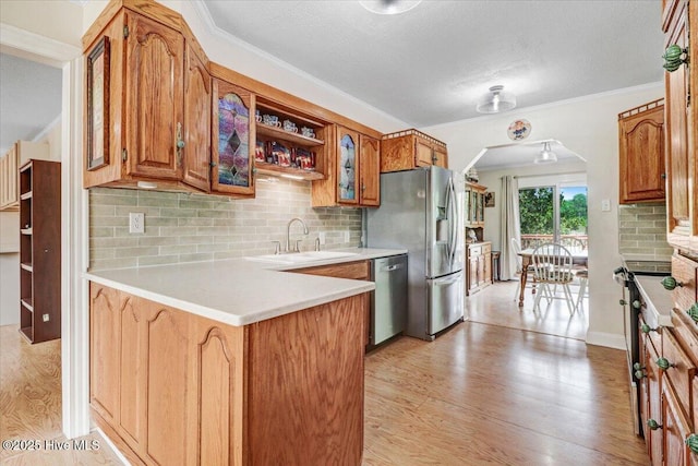 105 Harbor Dr, Washington, NC 27889 - kitchen featuring brown cabinets, a sink, a peninsula, backsplash, and appliances with stainless steel finishes