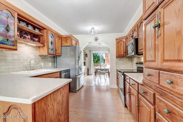 105 Harbor Dr, Washington, NC 27889 - kitchen featuring brown cabinets, tasteful backsplash, a sink, appliances with stainless steel finishes, and arched walkways