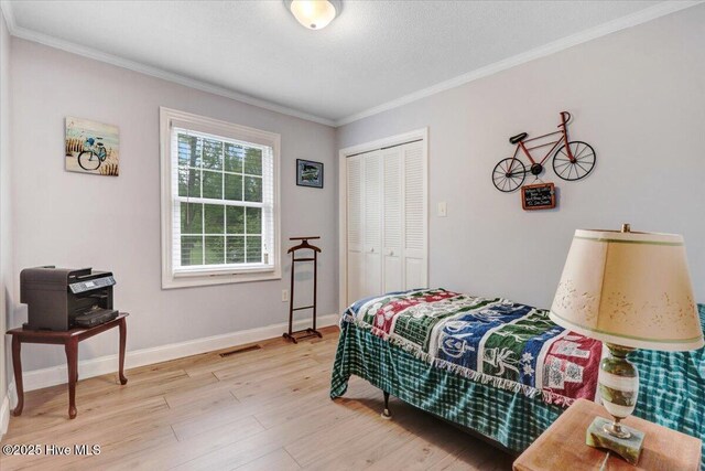 105 Harbor Dr, Washington, NC 27889 - bedroom with a closet, ornamental molding, light wood-type flooring, baseboards, and visible vents