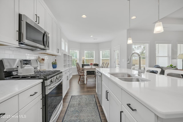 kitchen featuring recessed lighting, a sink, dark wood-style flooring, stainless steel appliances, and light countertops