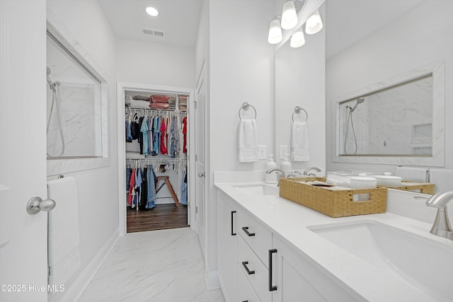 full bathroom with a sink, marble finish floor, visible vents, walk in shower, and a spacious closet
