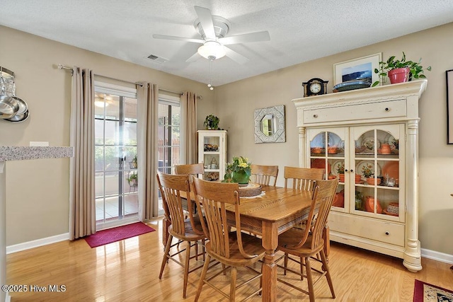 1005 Bellmark Ct, Leland, NC 28451 - dining room with light wood finished floors, a ceiling fan, baseboards, and a textured ceiling
