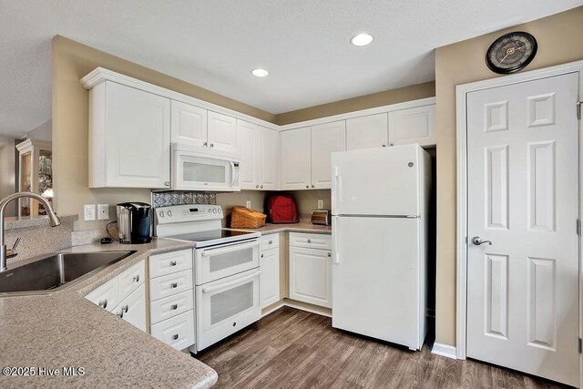 1005 Bellmark Ct, Leland, NC 28451 - kitchen with white appliances, a sink, recessed lighting, light countertops, and white cabinets