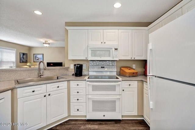 1005 Bellmark Ct, Leland, NC 28451 - kitchen featuring white appliances, a sink, white cabinets, recessed lighting, and dark wood-style flooring