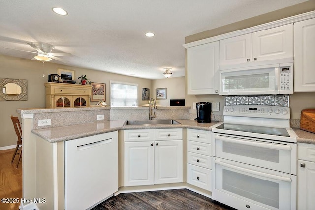 1005 Bellmark Ct, Leland, NC 28451 - kitchen featuring white appliances, a sink, a peninsula, dark wood finished floors, and recessed lighting