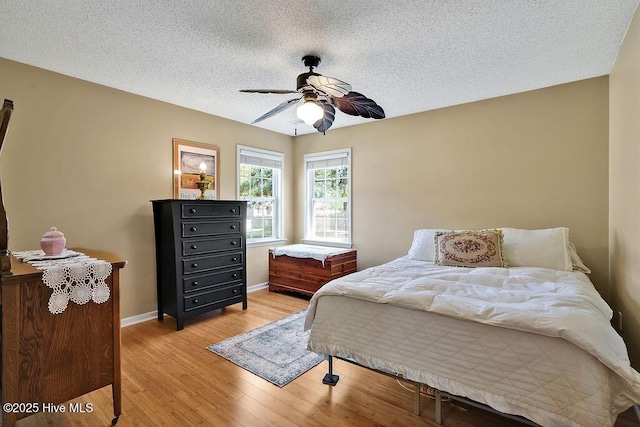 1005 Bellmark Ct, Leland, NC 28451 - bedroom featuring light wood-style flooring, a textured ceiling, baseboards, and a ceiling fan