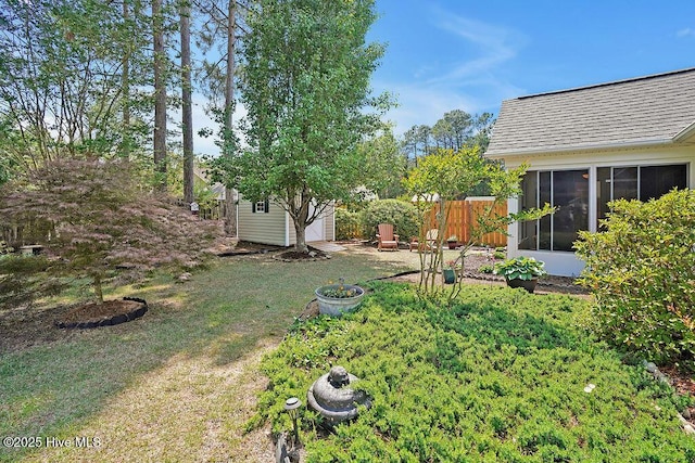 1005 Bellmark Ct, Leland, NC 28451 - view of yard featuring a sunroom, a storage shed, an outdoor structure, and fence