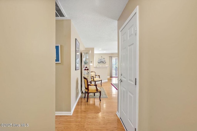 1005 Bellmark Ct, Leland, NC 28451 - hallway featuring a textured ceiling, light wood-type flooring, and baseboards