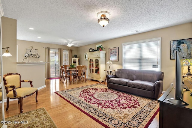 1005 Bellmark Ct, Leland, NC 28451 - living room featuring plenty of natural light, a textured ceiling, a ceiling fan, wood finished floors, and recessed lighting