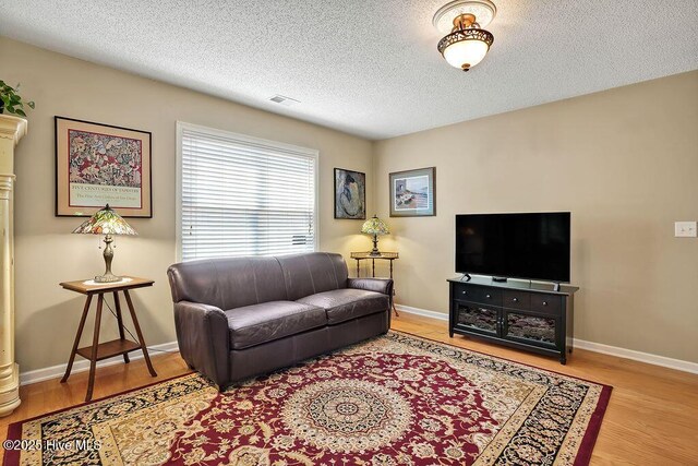 1005 Bellmark Ct, Leland, NC 28451 - living area with wood finished floors, a textured ceiling, and baseboards