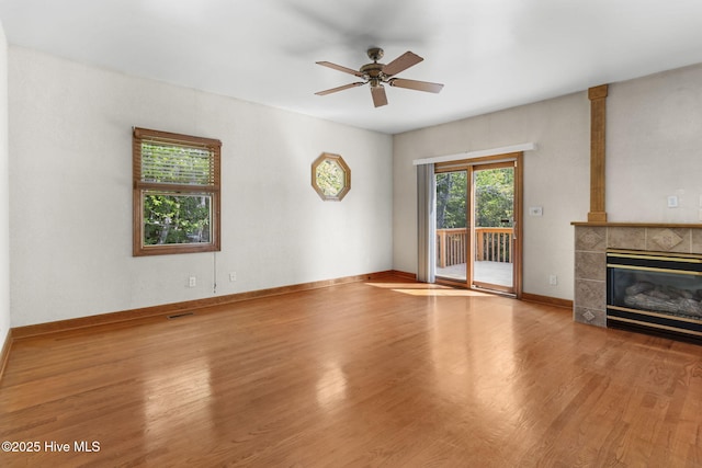 163 Middleton Dr, Hertford, NC 27944 - unfurnished living room featuring wood finished floors, a tile fireplace, baseboards, visible vents, and a ceiling fan