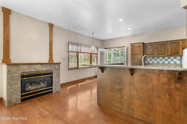 163 Middleton Dr, Hertford, NC 27944 - kitchen featuring a kitchen breakfast bar, light stone countertops, light wood finished floors, and baseboards